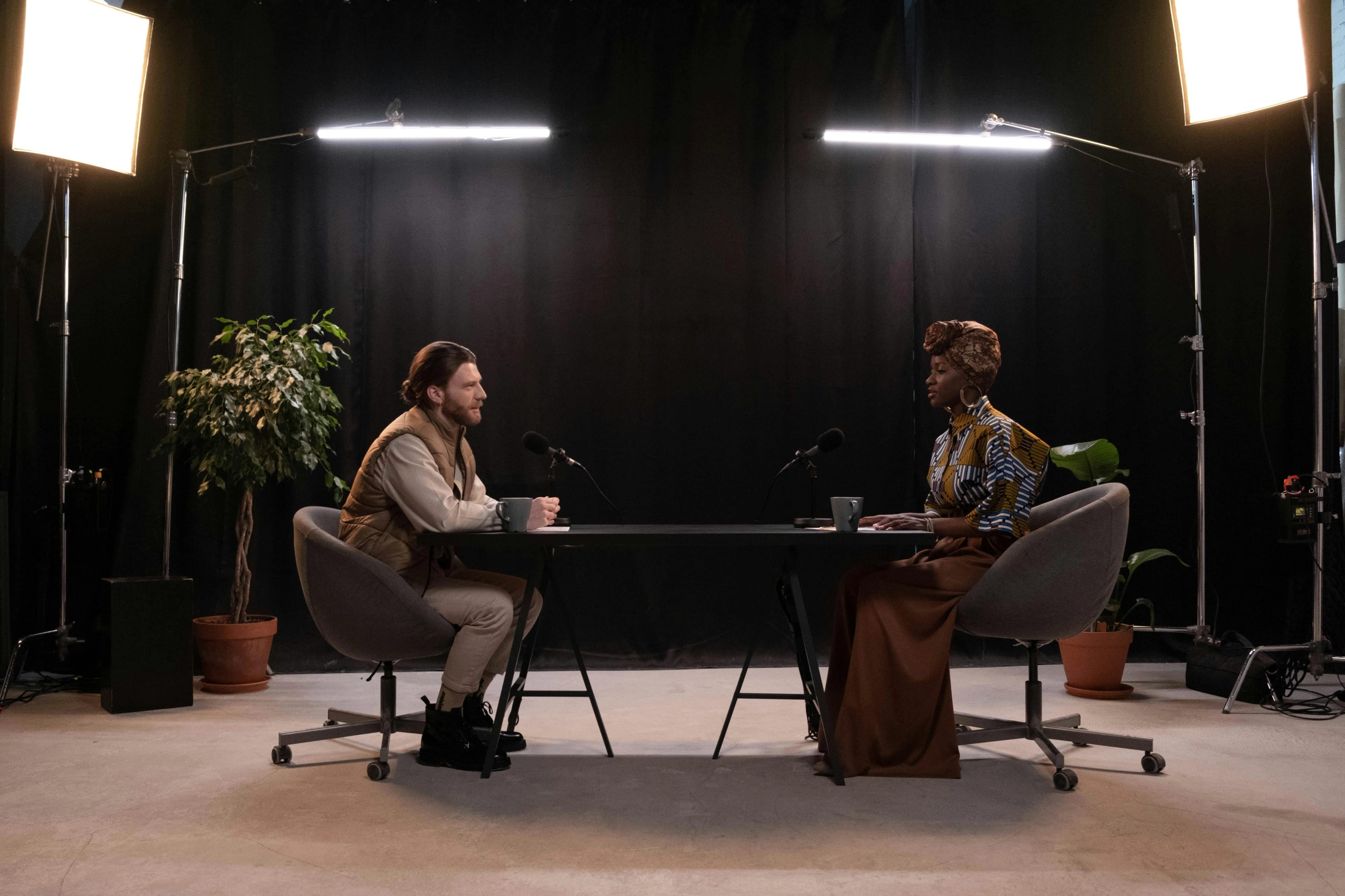 Two people sitting in a studio recording a podcast